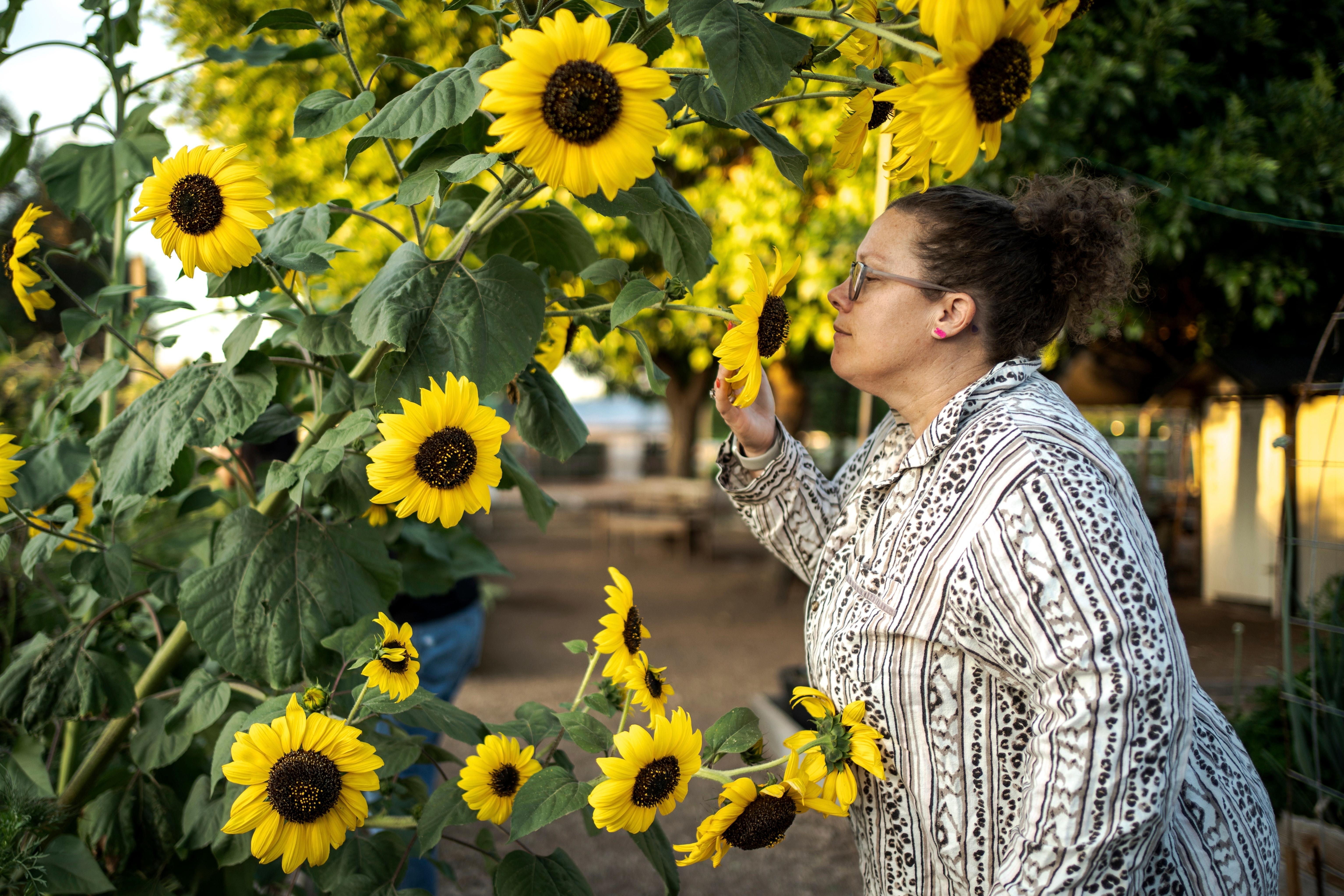 Sabrina Mathisen stops to smell the flowers at a garden...