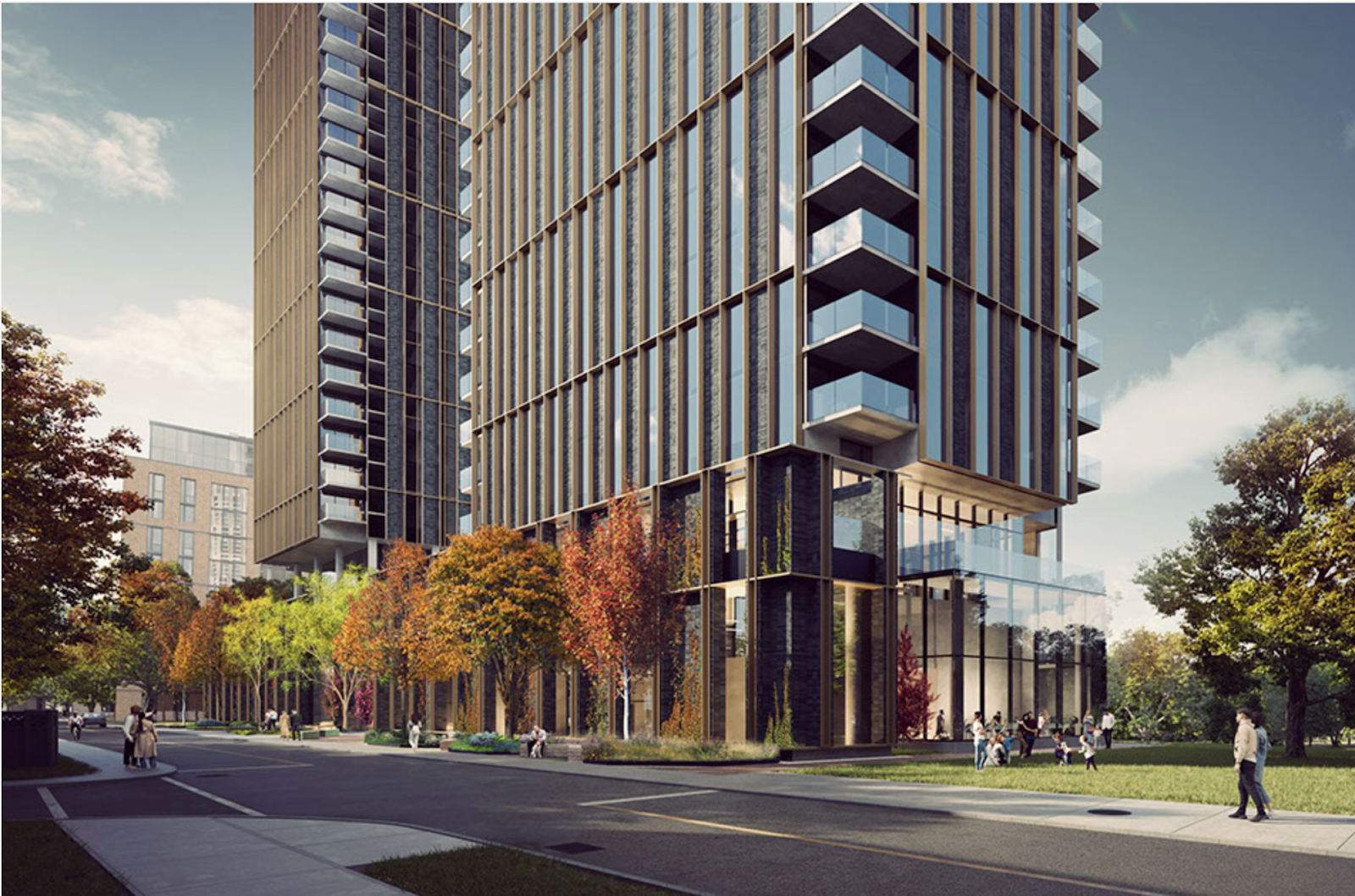 Modern high-rise buildings with glass facades and balconies, surrounded by trees with autumn foliage; people are walking on the sidewalk below.