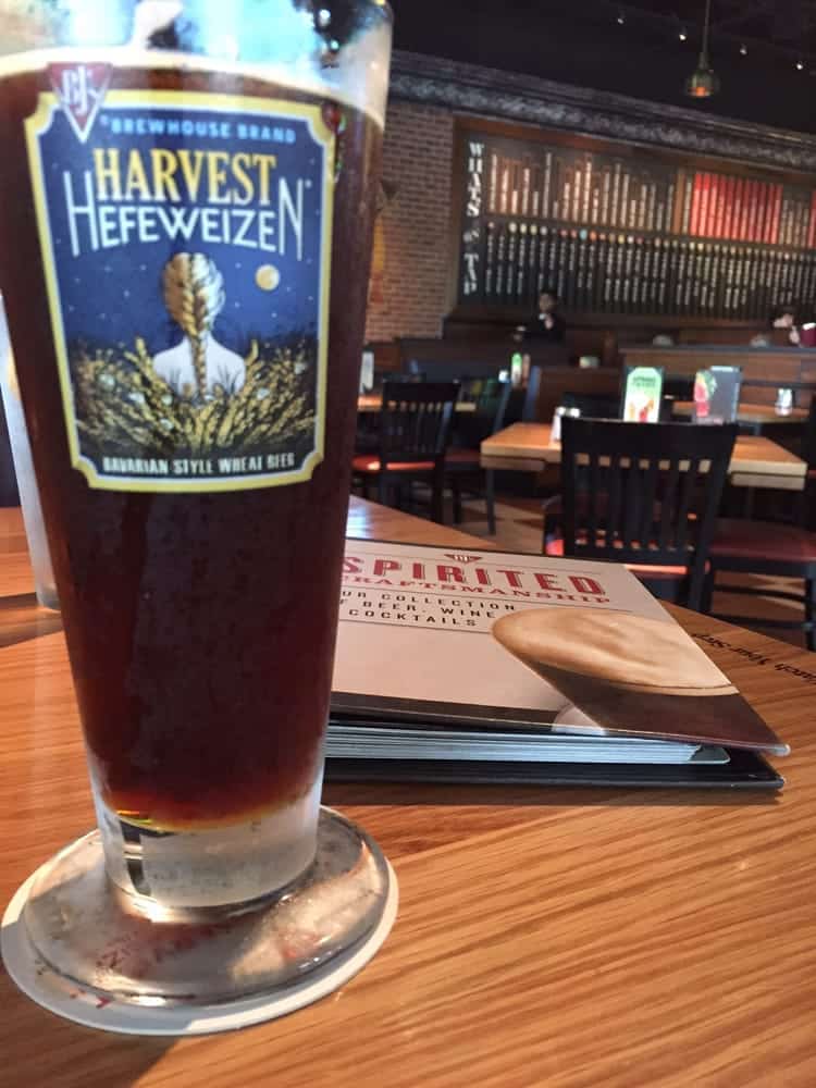 A pint of beer in front of the beer list at BJ's Restaurant and Brewhouse