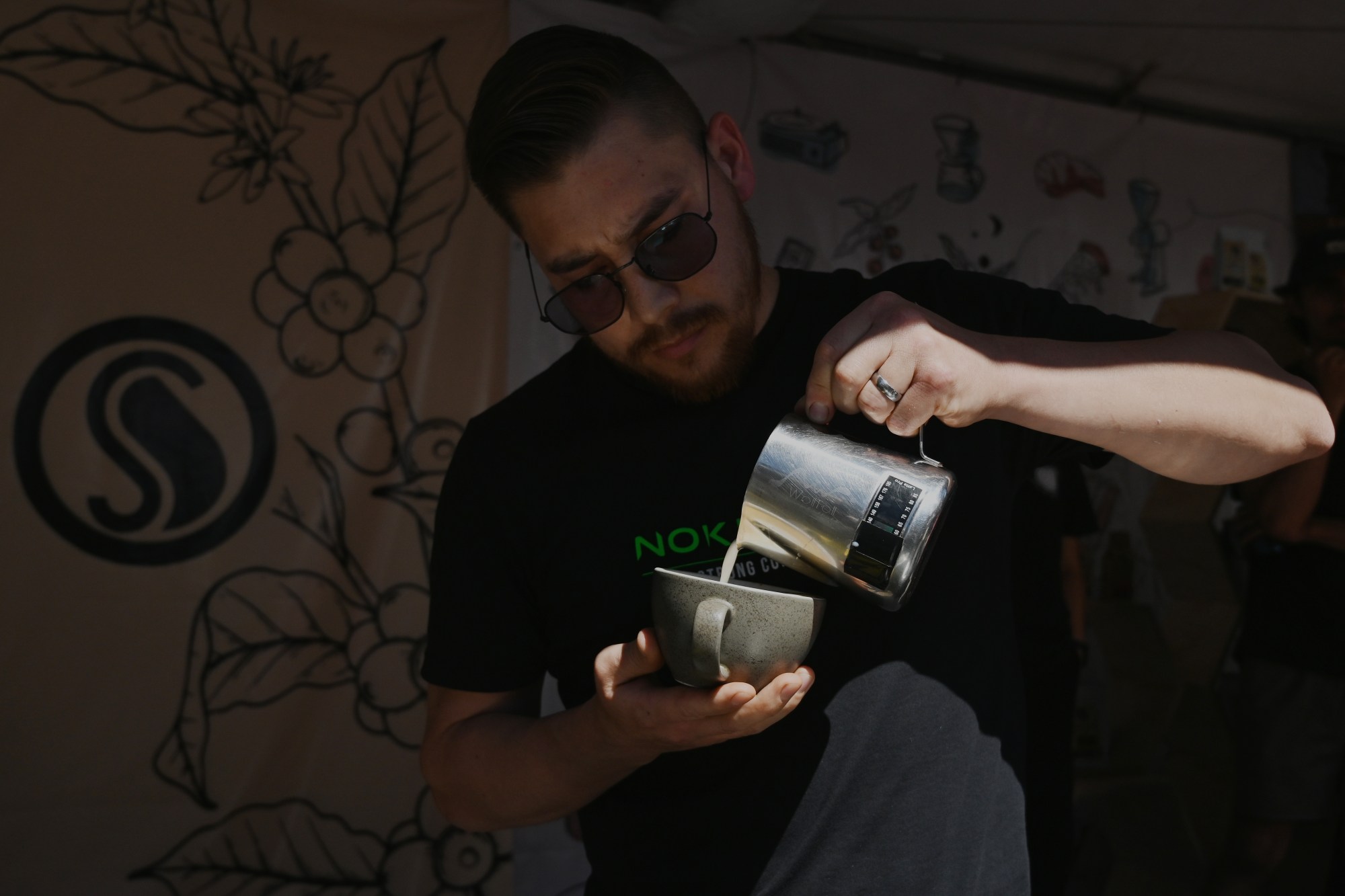 Barista Jose Luis Anaya Rojo from Nokrypt coffee shop prepares to serve a latte as he pours milk during the "Tijuana With The Smell of Coffee" festival at downtown's Revolution Avenue on Saturday. Baristas from different Tijuana coffee shops like Container Coffee Roasters Co., C Cafetero, and Nokrypt Coffee competed separately in a variety of coffee making categories and skill levels. For many of them it was their first time competing in front of the general public. (Carlos Moreno / The San Diego Union-Tribune)