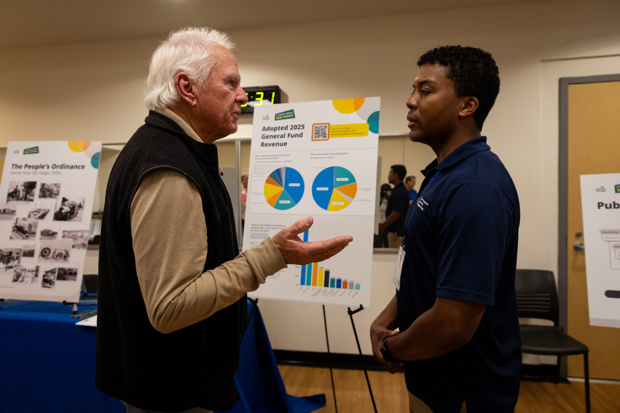Point Loma resident Michael Klose, left, asks Ian Ralph, assistant management analyst of environmental services, about the city's new trash pickup plans on Monday, April 7, 2025 in San Diego. (Ana Ramirez / The San Diego Union-Tribune)