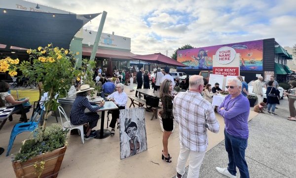 Guests pack The Flower Pot Cafe and Bakery on Fay Avenue beneath Chitra Ganesh's mural "Resurgence" (right) during Murals of La Jolla's Parking Lot Party in 2022. This year's event is set for Sunday, Oct. 19. (File)