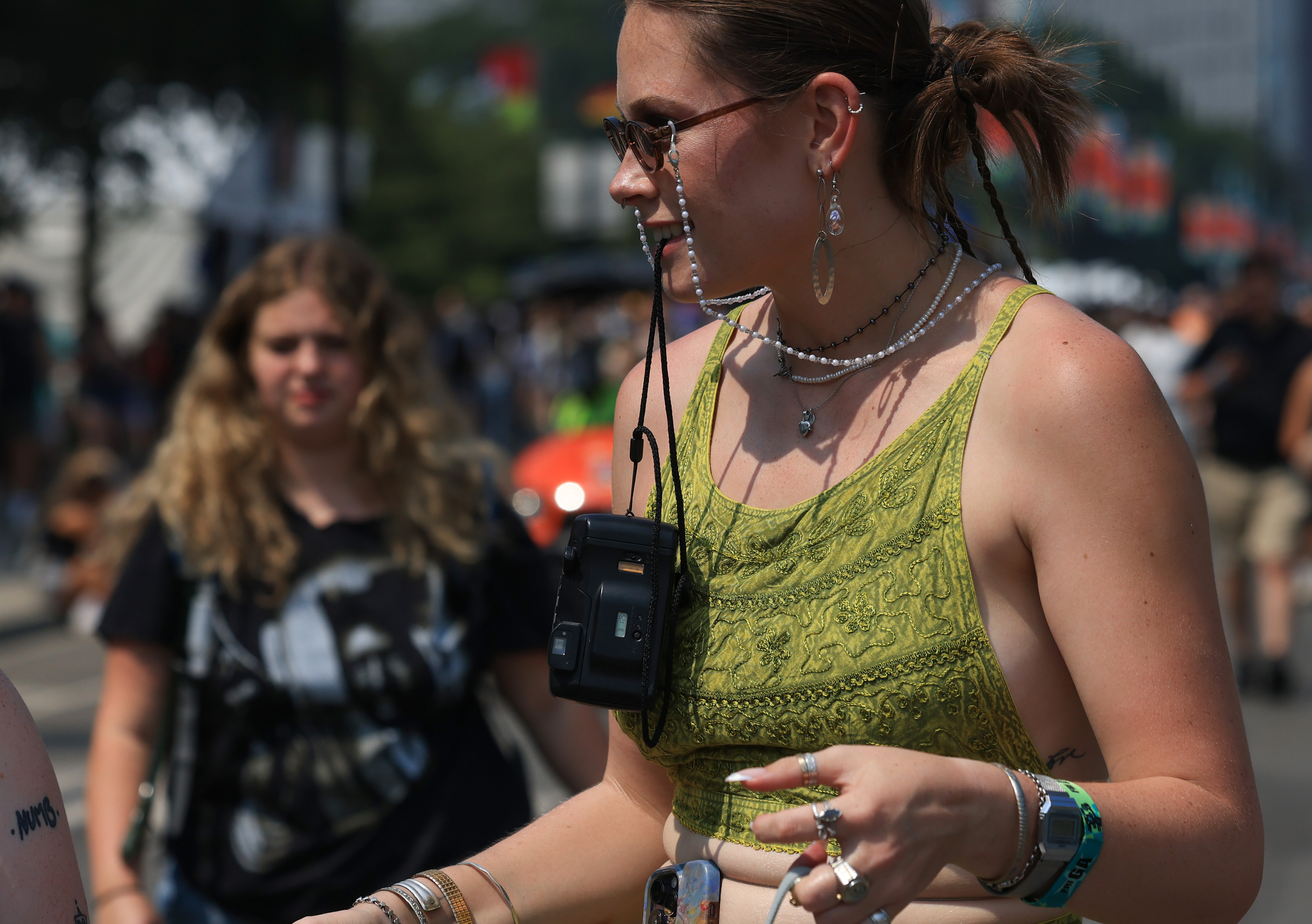 A festival attendee holds a film camera strap with her...