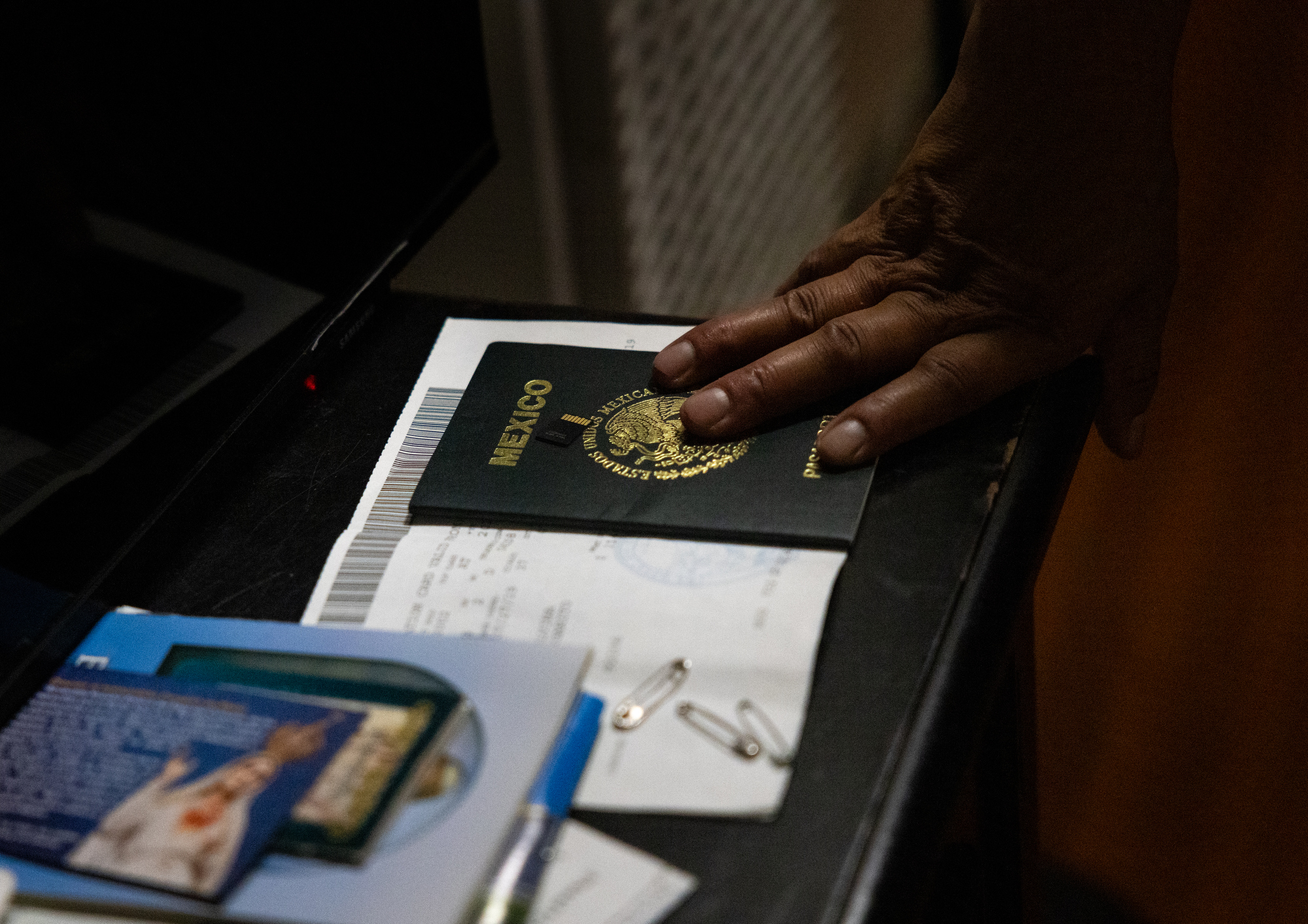 Etelvina Lázaro rests her hand on a passport. (Ana Ramirez / The San Diego Union-Tribune)