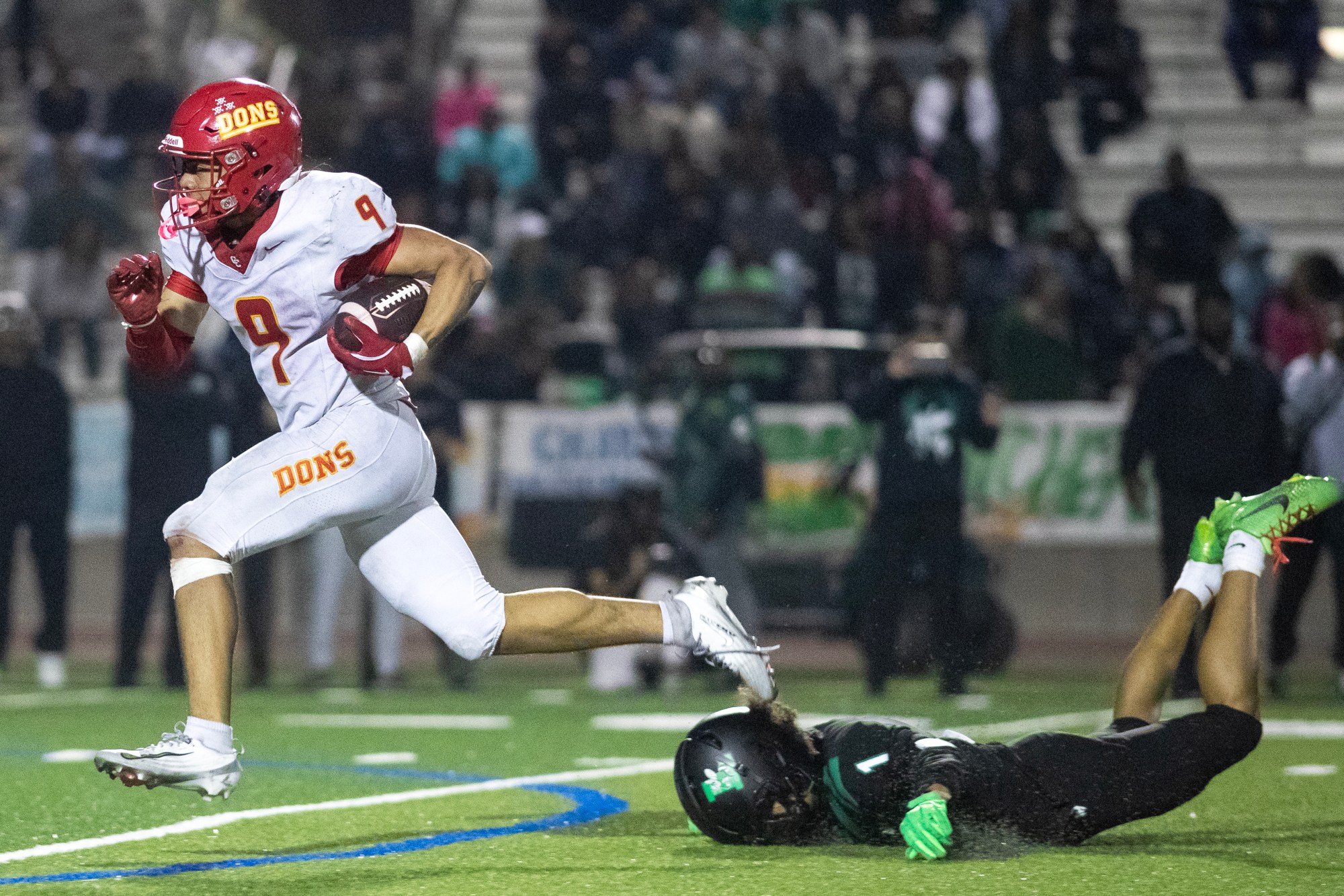 Cathedral Catholic High School's Honor Faalave (9) leaves Lincoln High's, Cammeron Purnell (1) face down as he runs the ball during Friday's football game at Lincoln High School in San Diego, CA. (Xavier Hernandez / For The San Diego Union-Tribune)