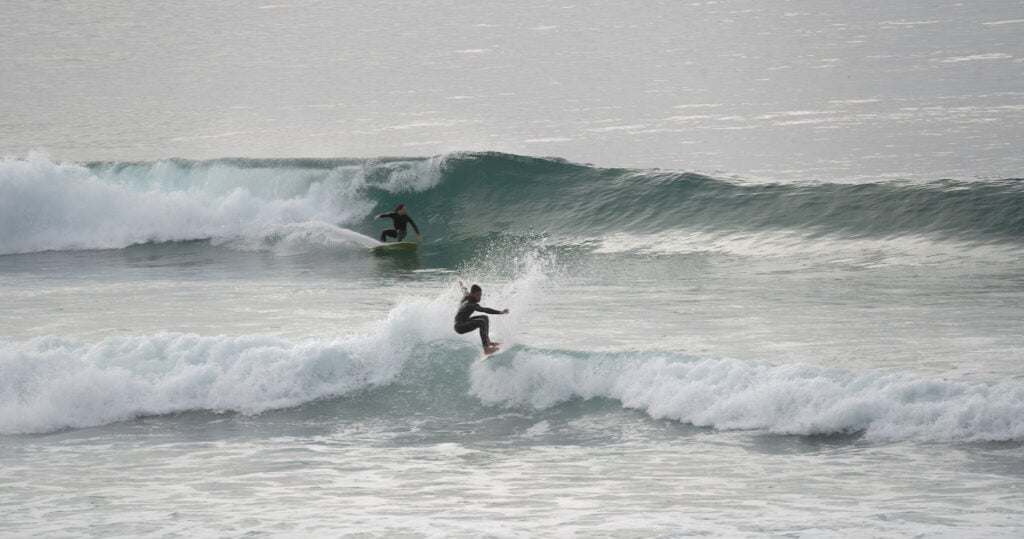 Surfers riding waves at Scripps Pier and La Jolla Shores