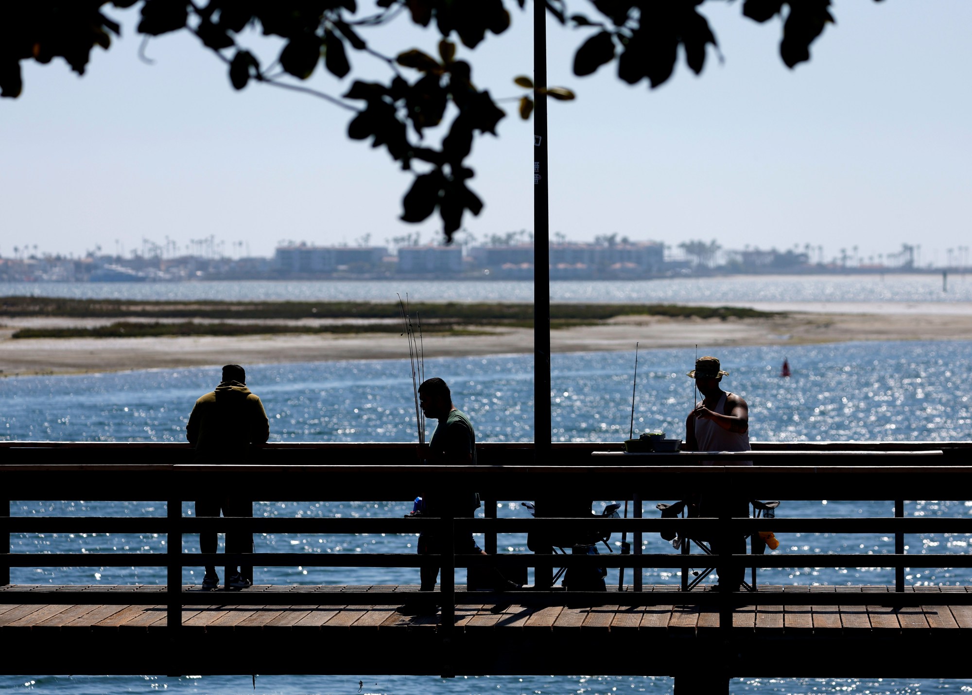 People fish off a pier in National City where rents have risen 0.8% annually. (K.C. Alfred / The San Diego Union-Tribune)