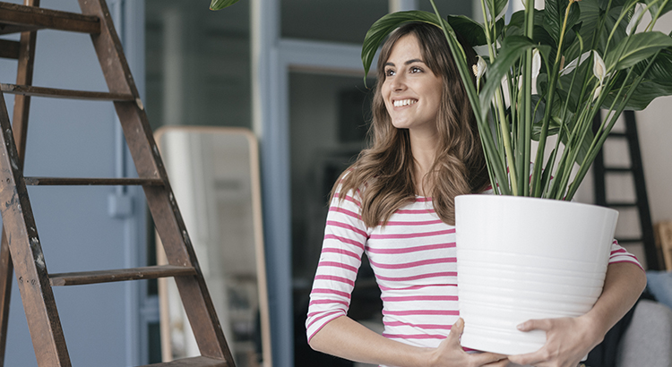 A woman carrying a big plant pot