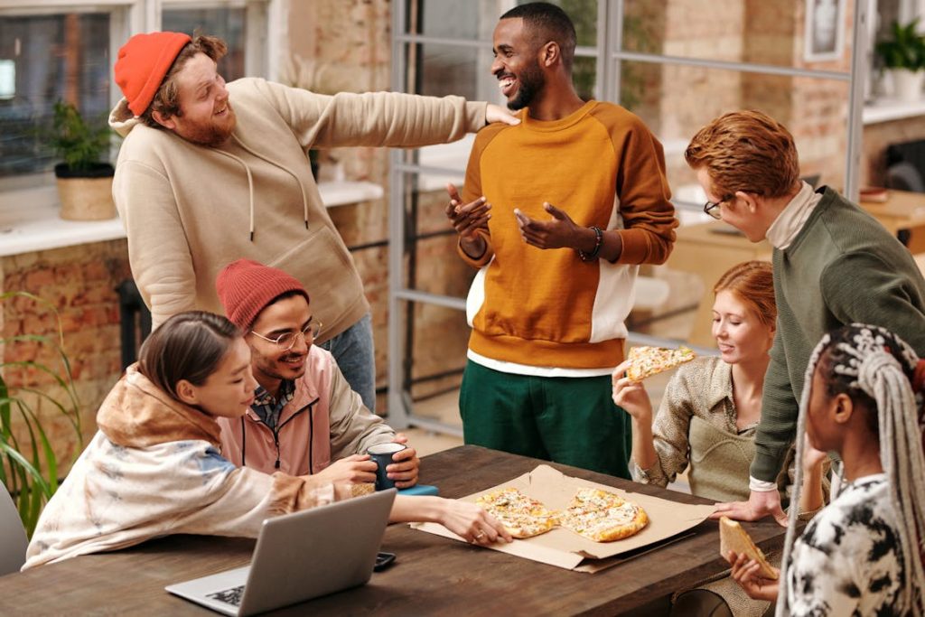 Group of People by the Table eating pizza.