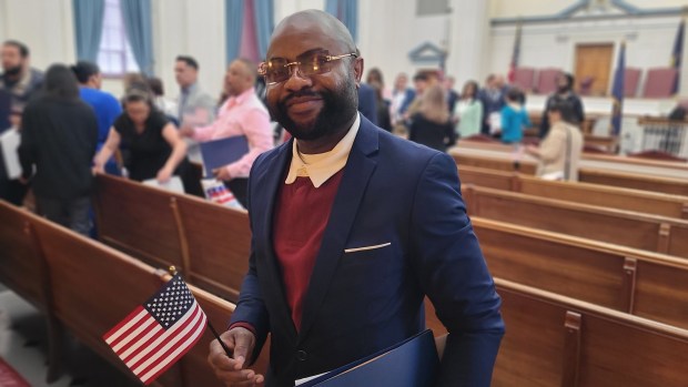 Felix Igharo, 42, of Reading, poses after becoming a U.S. citizen during a naturalization ceremony Wednesday held at Berks County Courthouse. (DAVID MEKEEL - READING EAGLE)