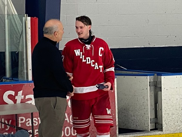 OJR captain and game-winning goal scorer Cael Primanti shakes hands with ICSHL President John Graves.