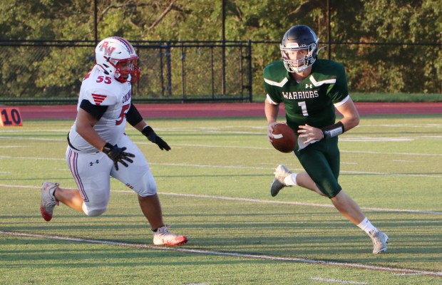Methacton quarterback Kolby Howarth (1) rolls out of the pocket past Plymouth Whitemarsh's Eddie Moyett (55) during a non-league football game at Methacton High School on Aug. 31. (Evan Wheaton - MediaNews Group)