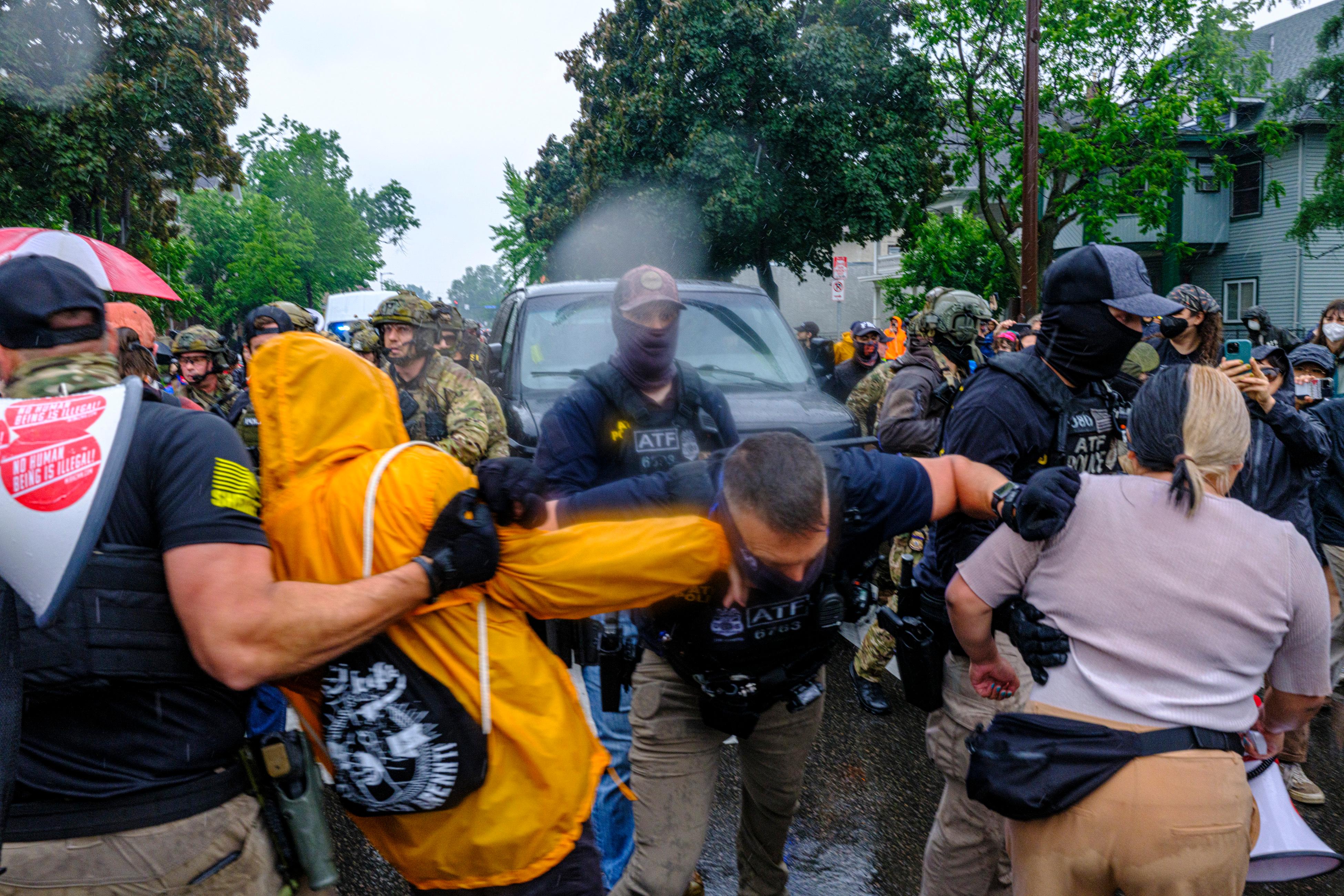 Protesters confront ICE, ATF, and FBI officers as federal agents...