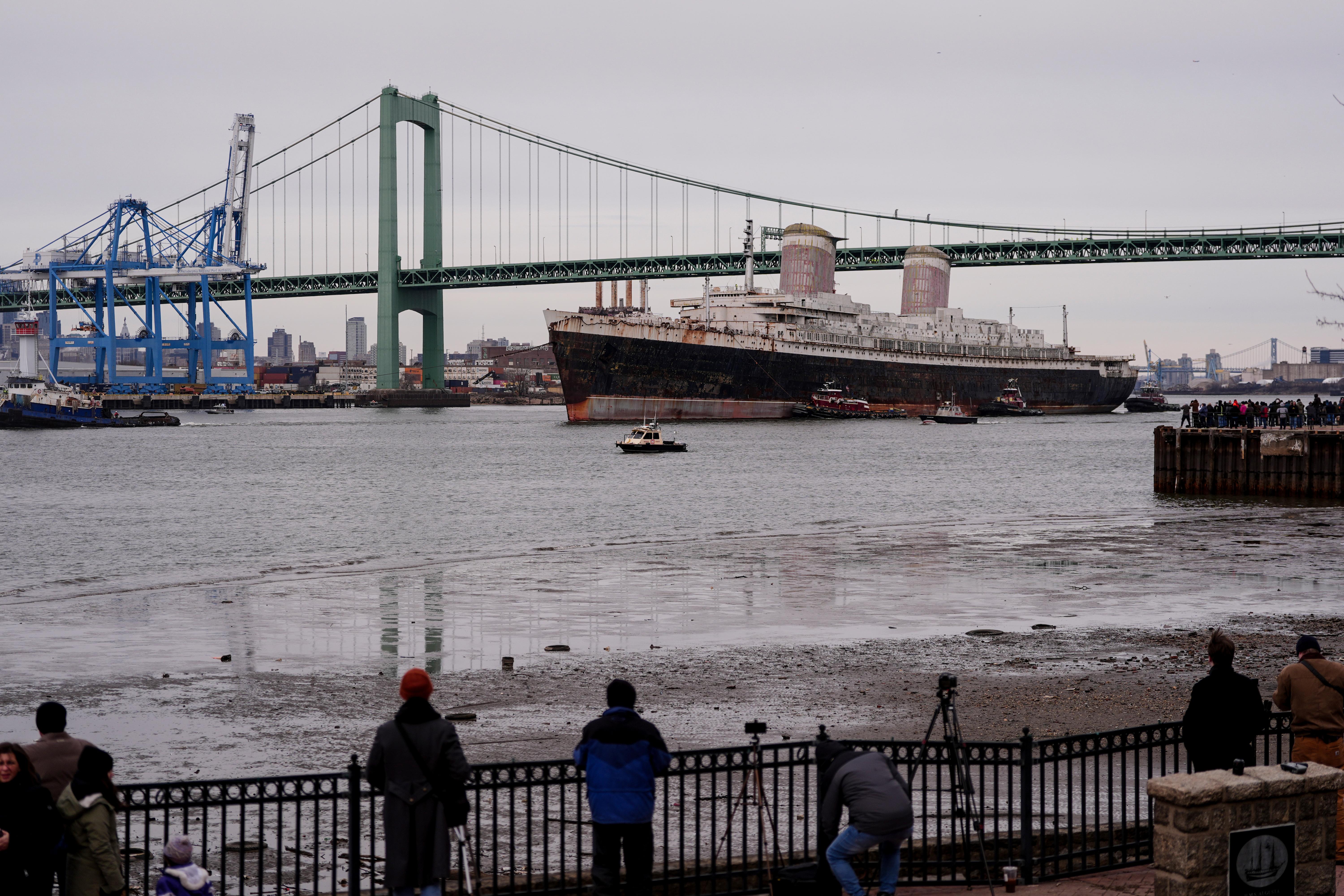 The SS United States is towed down the Delaware River...
