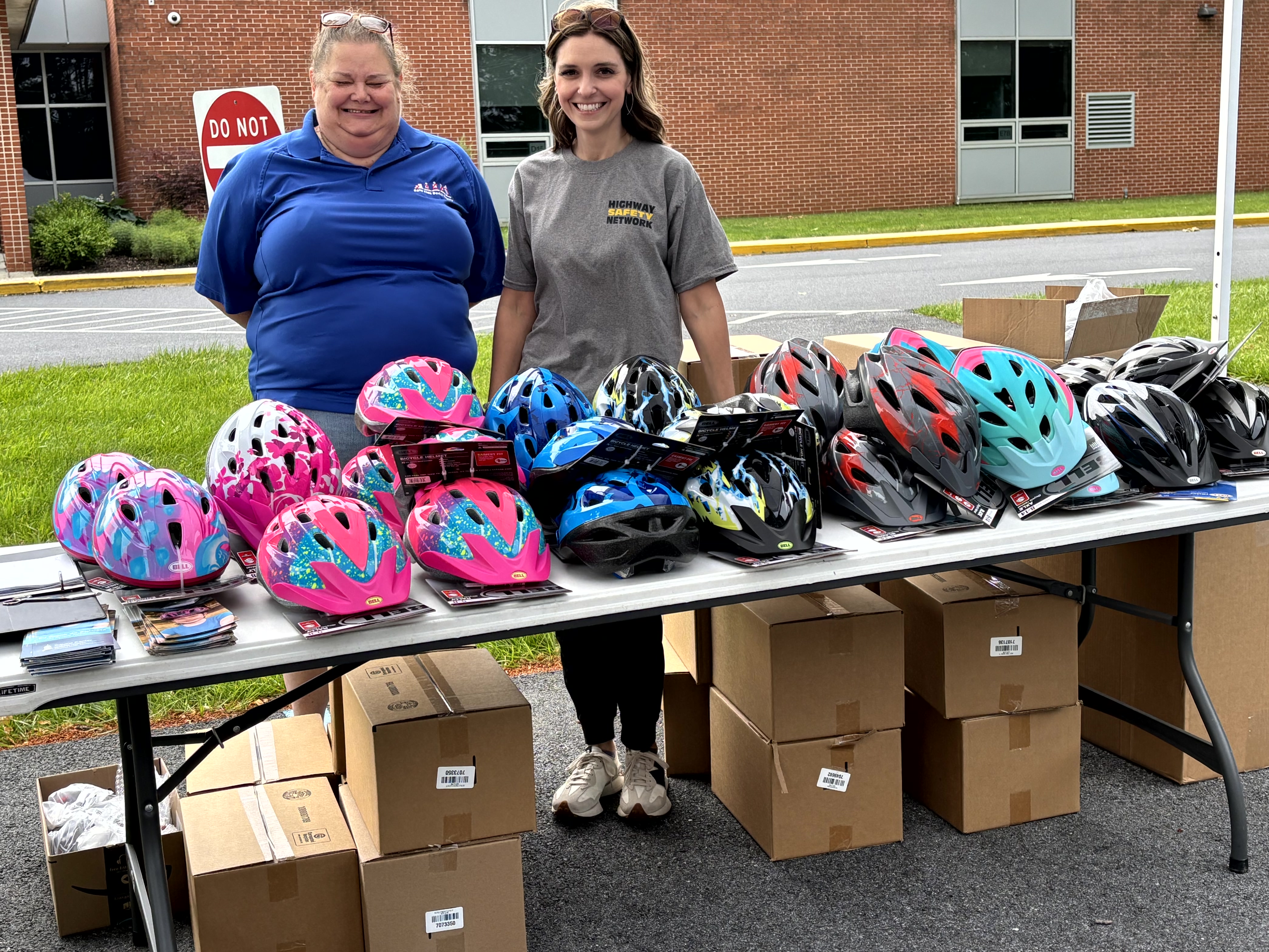 Sue Earnst and Tara DeStefano hand out free bike helmets...