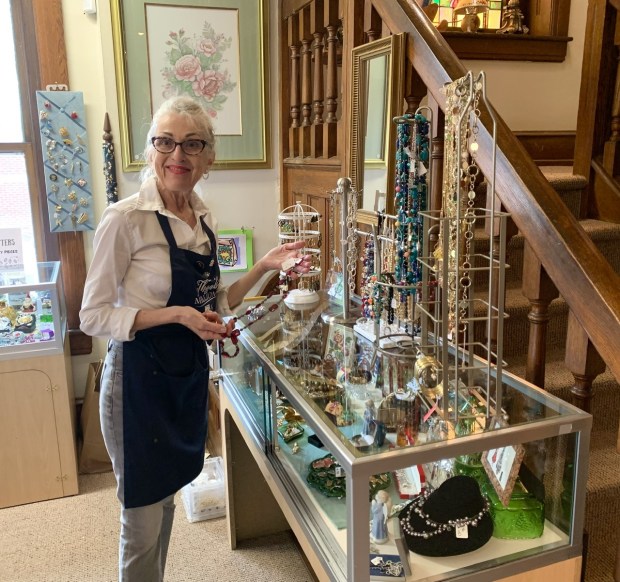 Volunteer Barbara Kane arranges newly donated jewelry in the display shelf at the Phoenixville Hospital Thrift Shop's new location, 822 Main St. in Phoenixville. (Virginia Lindak - For MediaNews Group)