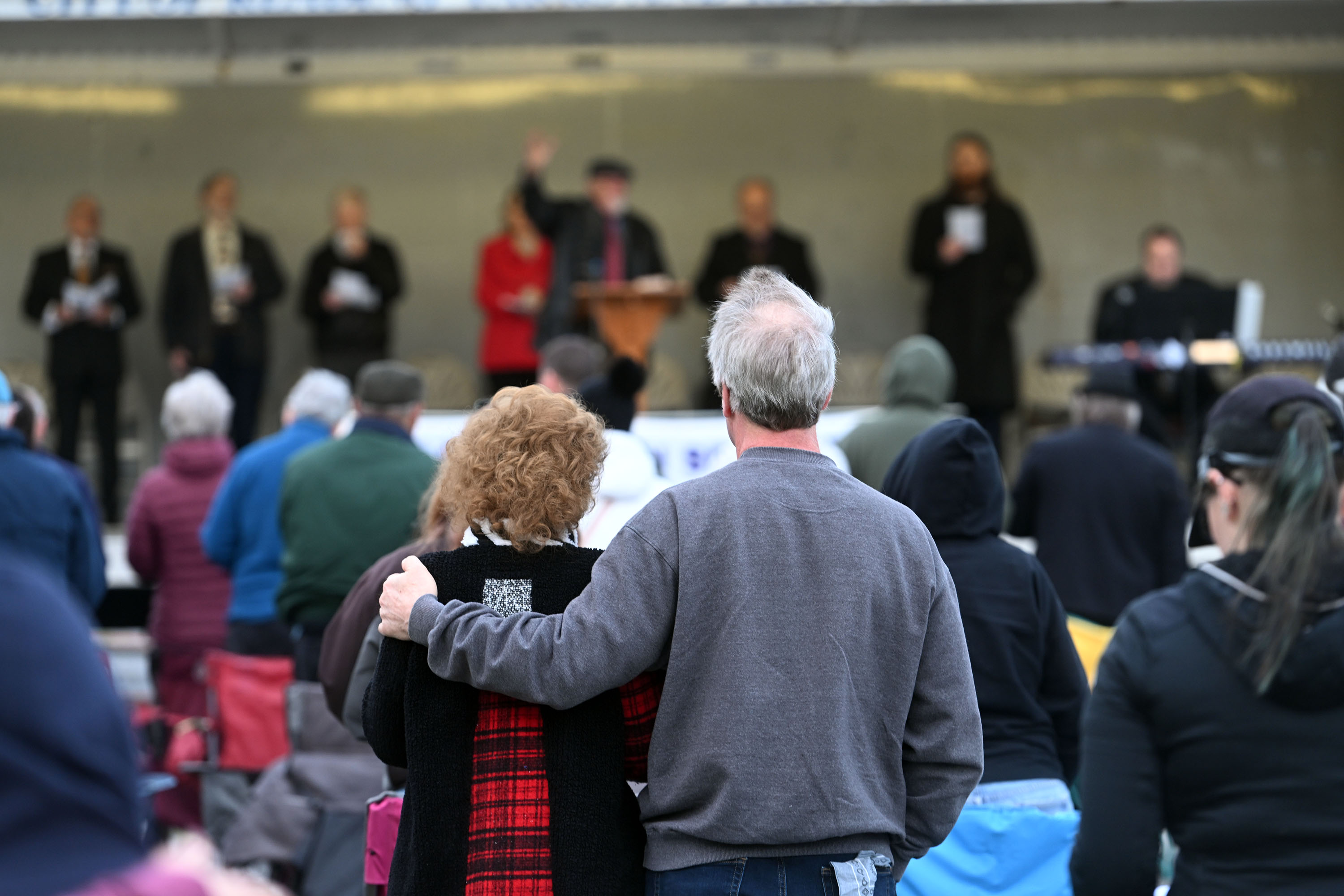 A couple listens to the Rev. Calvin Kurtz as he...