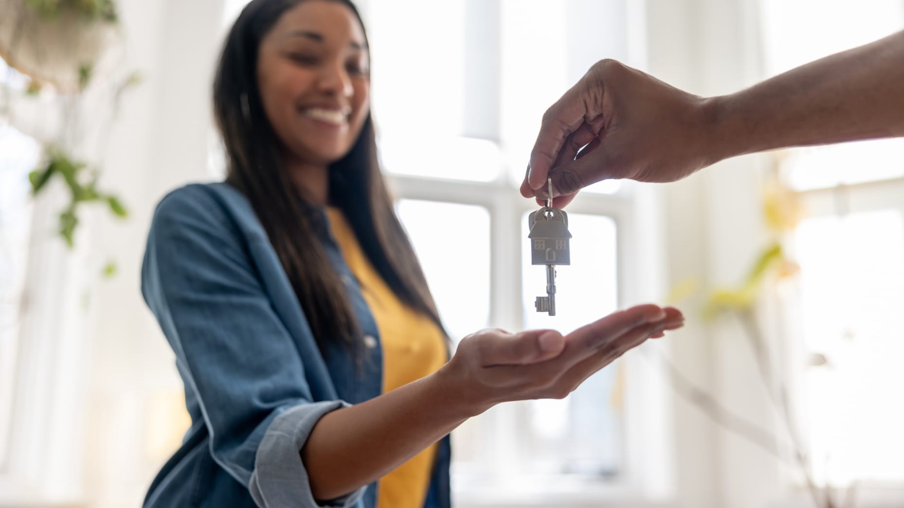 Close-up on a happy homeowner receiving the keys of her new house - real estate concepts